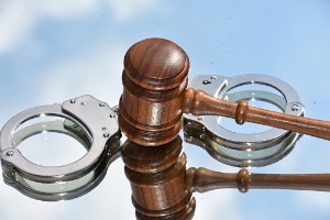 A gavel in the middle of handcuffs, representing a Defense Attorney in Peoria IL
