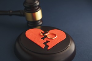 A gavel with a ripped heart and two rings, representing a Contested Divorce in Peoria IL
