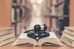 A law library and judge's gavel are seen. Brave Law Center, P.C., is a Criminal Defense Lawyer in Peoria IL.